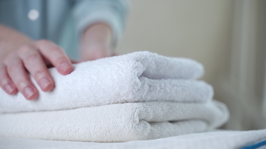 A woman touches a fresh white towel | Shutterstock HD Video #1053442364