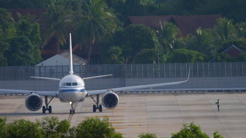 PHUKET, THAILAND - NOVEMBER 26, 2019: Air China Airbus 321 begin taxiing before departure. View from the top floor of the hotel near airport