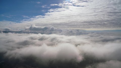 Cinematic 8K 7680x4320.Two different layers of cloud time-lapse.Above the clouds over from mountain summit.Vast landscape.Overcast layer.A sea of fog is formed from stratus.Foggy valley mount ridge na
