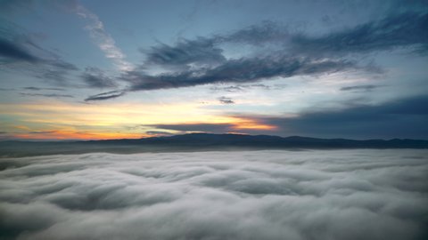 Cinematic 8K 7680x4320. Standard sunrise cloud movements in morning sky.A sea of fog is formed from stratus. Above the clouds over. Flat surface. Cloudy mixed sunny day mix time lapse vast hill aerial