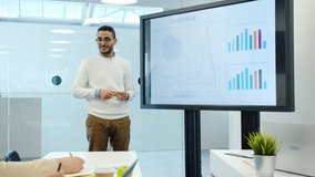 Arab man discussing marketing research with group of people in office using interactive board for presentation talking and gesturing indoors. - Powered by Shutterstock - Get 15% off with code: PIKWIZARD15