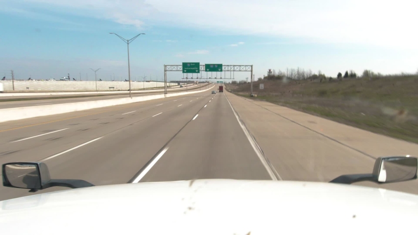 White semi truck driving on an empty interstate towards Indianapolis, Indiana during the Covid stay at home order. It's a bright and sunny day Royalty-Free Stock Footage #1053453464