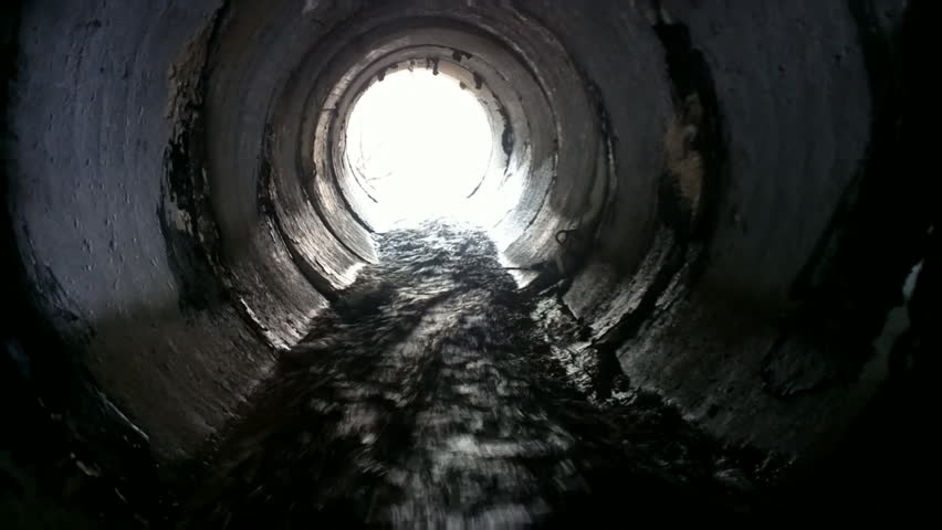 Drainage pipe under the highway (culvert). Filming inside the pipe. Noise is water Royalty-Free Stock Footage #10534544