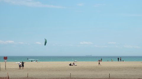 Toronto, Ontario, Canada - May 24, 2020 Lake Ontario Woodbine Beach on sunny day with wind kite surfers and people leisure, during COVID 19 coronavirus pandemic. Marine summer landscape.