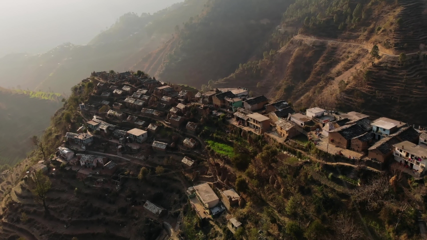 4k, Aerial view of Rural terrace farming  on a hilly landscape and Himalayan village of Uttarakhand, India, with mud Houses and cow shelters on a hill top. Drone view | Shutterstock HD Video #1053476276