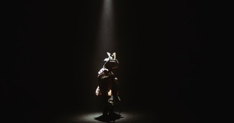 Asian man in traditional samurai costume swinging his quarterstaff as if fighting an enemy, isolated on black background - culture, tradition concept 4k footage