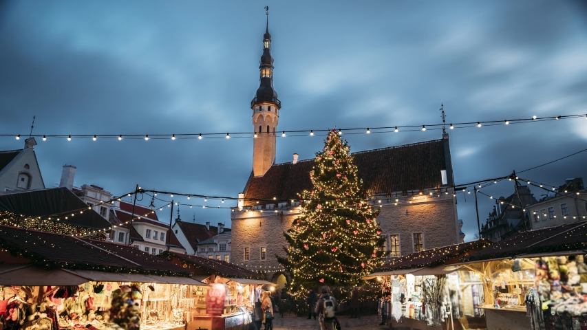 Set. Tallinn, Estonia. Time-lapse Of Traditional Christmas Market In Town Hall Square. Christmas Tree And Trading Houses. UNESCO World Heritage Site. Set. And Time-lapse From Night To Day