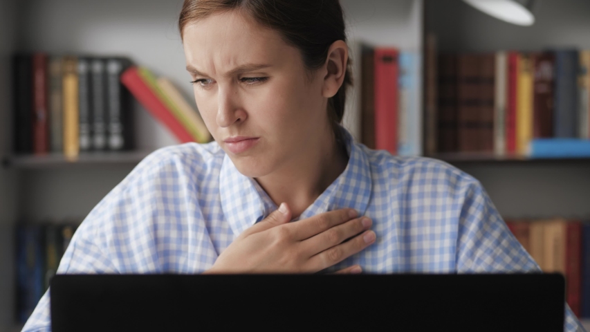Trouble breathing, chest pain. Close-up woman working at computer, she has difficulty breathing or pain in chest touches chest with her hand. Panic attack, asthma, osteochondrosis concepts | Shutterstock HD Video #1053483293