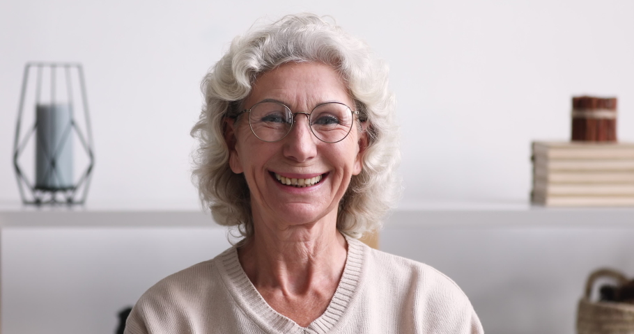 Head shot portrait of smiling mature older hoary woman in eyeglasses, feeling satisfied with optical clinic services. Happy healthy middle aged beautiful grandma looking at camera, retirement life. Royalty-Free Stock Footage #1053484508
