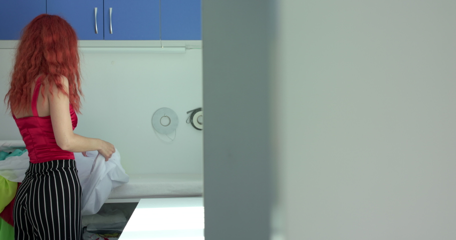 Happy female dressmaker lays out a color variety of silk for work in a modern studio. Slowly in 4K