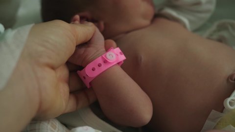 infant newborn hand arm wrist pink girl band hospital identification wristband