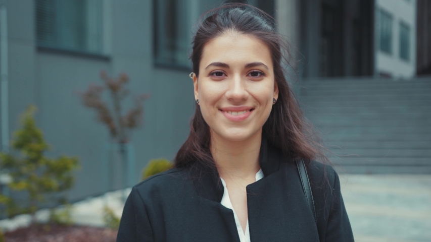Portrait of gorgeous pretty young woman caucasian girl business executive smiling cheerful standing outdoors corporate company building. Beautiful female. Close-up. | Shutterstock HD Video #1053503324