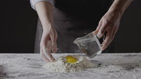 Step by step process of preparation homemade dough for pasta. Girl's hands knead natural products for dough on a kitchen table. Slow motion, Full HD video, 240fps, 1080p.