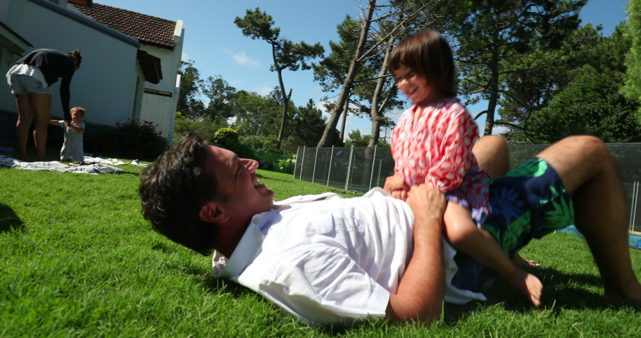 Father and daughter together lying on grass. Dad and child girl bonding
