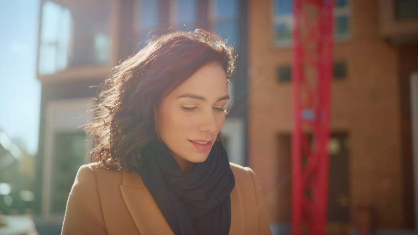 Portrait of a Gorgeous Dark Haired Hispanic Woman Smiling Charmingly while Standing in the Middle of Modern Urban City Landscape, Wearing Spring Coat. Happy Young Woman Enjoys Life | Shutterstock HD Video #1053526490