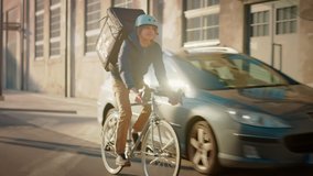 Happy Food Delivery Courier Wearing Thermal Backpack Rides a Bike on the Road To Deliver Orders for Clients and Customers. Sunny Day in Modern City with Stylish Urban Buildings. Front Following Shot - Powered by Shutterstock - Get 15% off with code: PIKWIZARD15