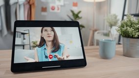 Tablet screen with Asian Beautiful woman in casual clothes video call conference chatting online on video calling app with smiling face and enjoying expression. lifestyle Communication Concept