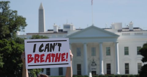 WASHINGTON DC - Circa May, 2020 - A man holds an I CAN'T BREATHE protest sign in front of the White House. This phrase was a commonly heard after the killing of George Floyd by police in Minnesota.	