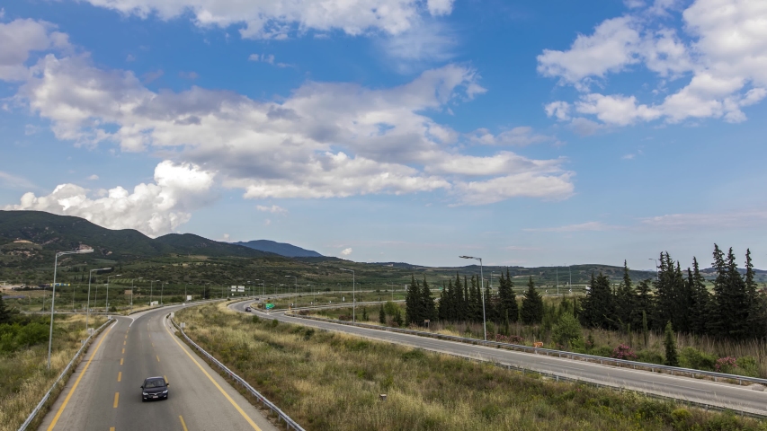 Time lapse of the national road (Egnatia Odos) in northern Greece. white clouds rolling over a blue sky