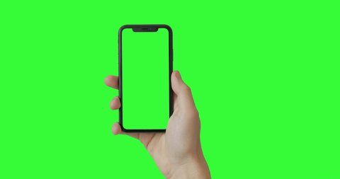 Man hand holding the smartphone on green screen chroma key background.  Mobile phone mock-up for your product. The iPhone Xr model in vertical orientation portrait mode. 2020 - USA, NY