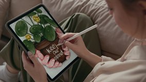 Ecological painting of young artist close-up. Talented pretty woman drawing flowerpot with plant. Tablet computer for art indoors home. Girl sketching color image by stylus at screen of digital pad - Powered by Shutterstock - Get 15% off with code: PIKWIZARD15
