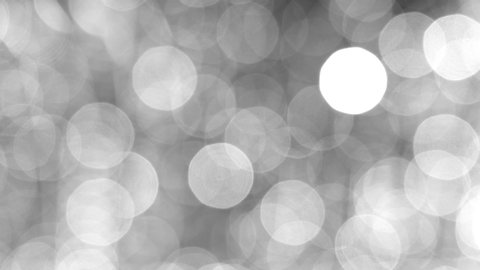 Blurred black and white abstract Christmas (Xmas) or New Year 4k video bokeh of blinking defocused holiday lights on dark background 