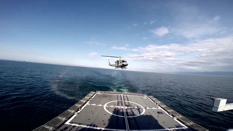 AB-212 ASW military helicopter lands on the deck of a battleship