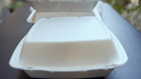 This closeup video shows an order of delicious chinese takeout fried pastry bun bread rolls being opened in a reveal by an anonymous hand.