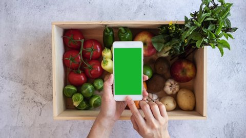 grocery vegan product gathering on the reusable bag with the mobile phone green screen interface on flat lay design. fresh vegetable online shopping and e commerce .stop motion video