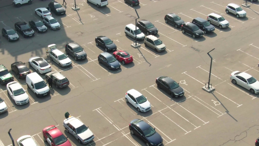 Aerial top view from drone of parking lot cars of the business center, shopping mall, supermarket or hospital with cars and empty parking spots at day. Transport. City. Urban.4k footage | Shutterstock HD Video #1053565250