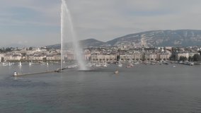 Geneva Switzerland Aeria shot. Drone flight over the city and the lake. Booths water, fountain, city center, mountain boats on the background.