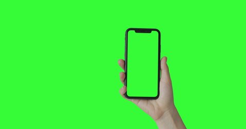 Woman hand holding the smartphone on green screen chroma key background.  Mobile phone mock-up for your product. The iPhone Xr model in vertical orientation portrait mode. 2020 - USA, California
