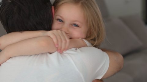 Portrait of a little girl with father. Happy daughter hugs and kissing father. 4k