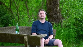 a man is sitting on a wooden bench in nature enjoying the summer day and relaxing
 - Powered by Shutterstock - Get 15% off with code: PIKWIZARD15