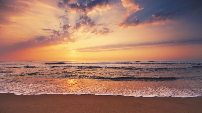 Dramatic sea sunrise. Burning sky and shining golden waves.  | Shutterstock HD Video #1053583796