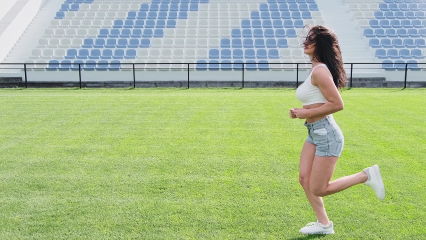 Sexy woman erotically runs on the grass, the wind blows her hair. Side view. Slow motion