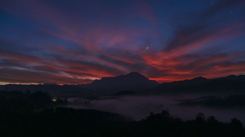 4K Timelapse of Amazing beautiful burning sky sunrise with Mount Kinabalu as background in rainforest jungle with foggy and cloud at Sabah, Borneo | Shutterstock HD Video #1053587696