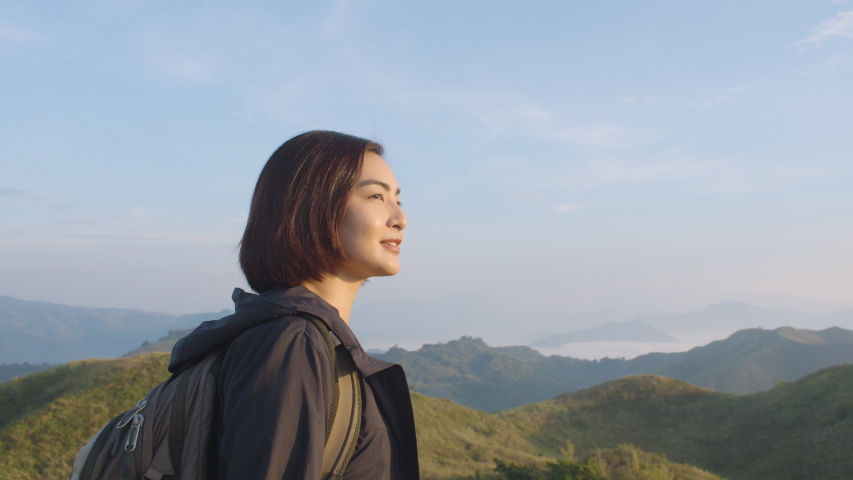 Side Shot Of Young Woman Enjoying The Sunrise View On Top Of A Mountain