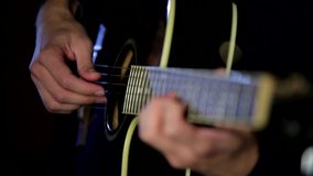 Male hands playing the guitar with a refocus from one hand to another