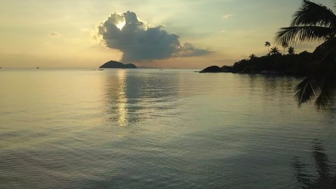 Drone footage of still water at dusk by coastline of Koh Phangan, Thailand