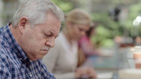 Pensive old man studying and reading school books with a group of young college students in public library. Rack focus from woman to elderly person writing as senior student continuing education - Powered by Shutterstock - Get 15% off with code: PIKWIZARD15