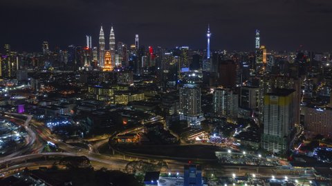 Kuala Lumpur Time lapse: Aerial Kuala Lumpur city at night overlooking KL skyline with busy roundabout and streets. Prores 4K