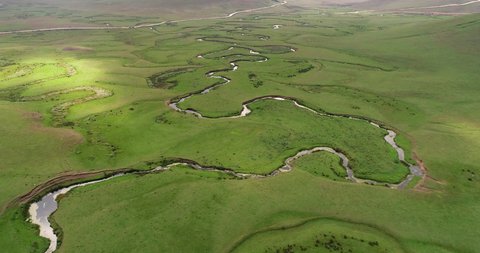 Meandering stream with mountains and clouds at The Persembe Plateau at Ordu, Turkey Drone and Aerial view. Nature, natural places. Village life.