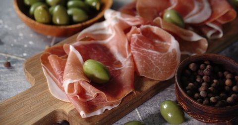 Fresh sliced antipasto on a wooden cutting Board. On a light background.
