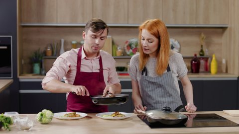 Cooking show hosts chefs, male and female, cooking in the kitchen studio set. Morning TV cooking programme. Shot on ARRI Alexa Mini