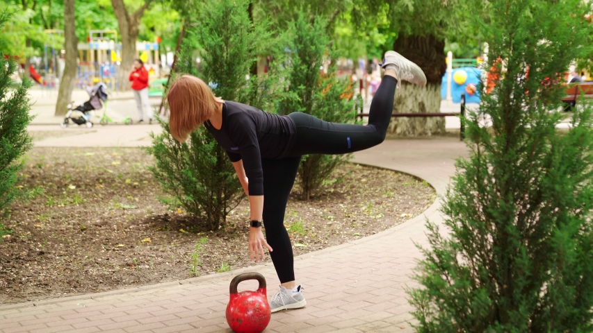 female athlete doing tilts and holds the balance on one leg. sport activities outdoors.