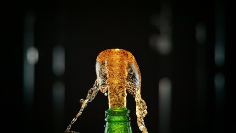 Macro Shot of a Cap Popping off the Green Bottle and Golden Carbonated Beer Splash Explosion. Phantom Flex 1000fps
