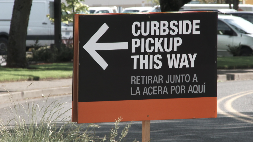 Close up on sign pointing drivers to curbside pickup at business as stores start to open back up during the coronavirus crisis. Royalty-Free Stock Footage #1053630146