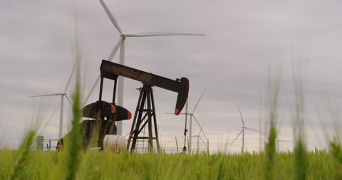 Wind turbines and an oil lifting pump jack share this wheat field in Oklahoma. A contrast in renewable and fossil fuels.