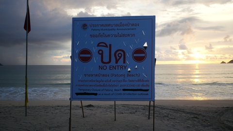 Sign of temporary closure Patong beach Phuket, Thailand. During  Coronavirus (Covid-19) pandemic prevention outbreak. Disapprove tourist and anyone do activities on beach and sea. Sea wave hit sand.